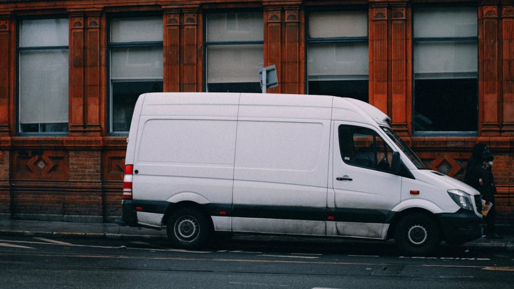 Acerca de Nosotros A white van parked alongside a red brick building in Dublin, Ireland.